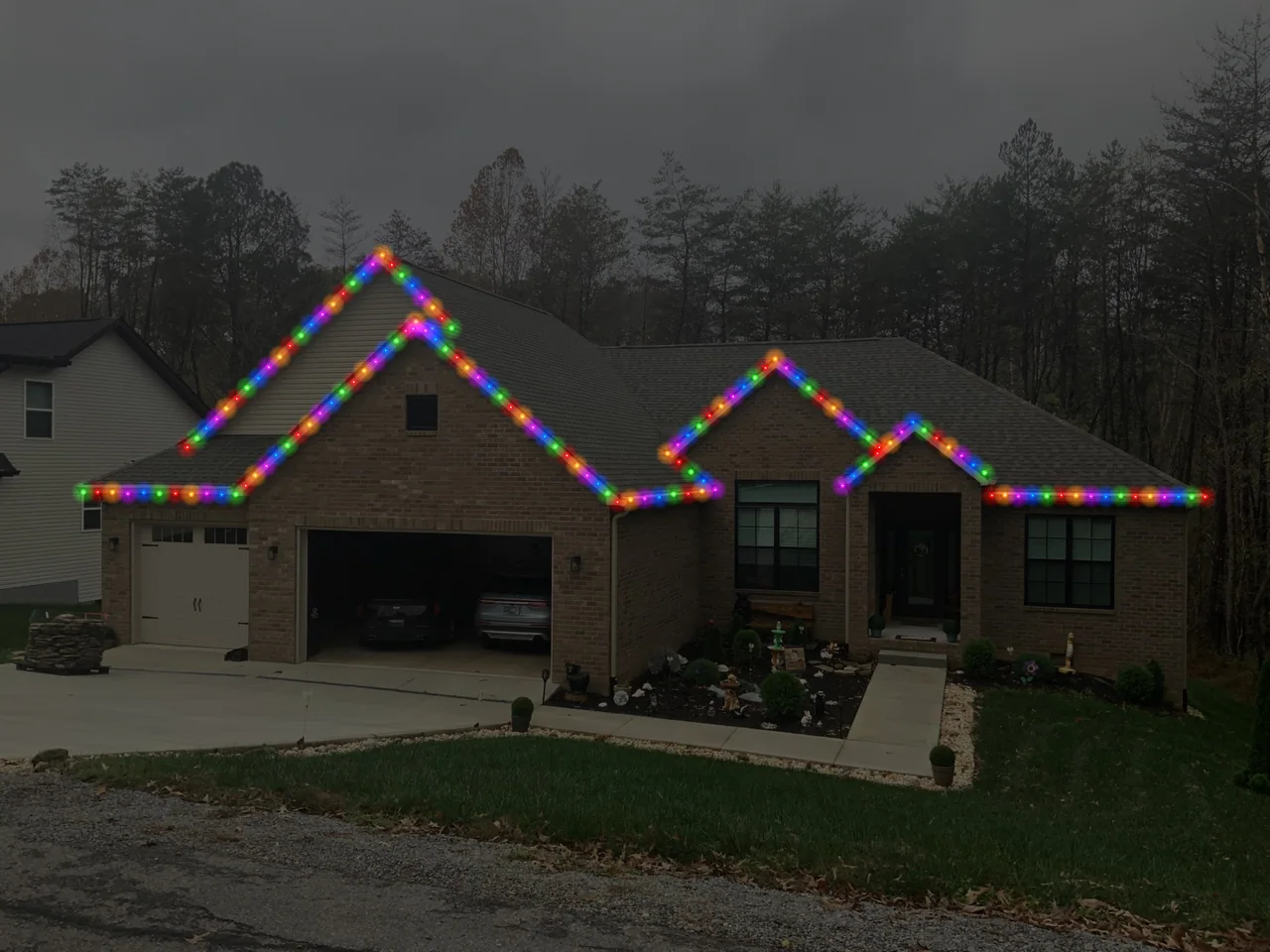 Design mockup showing multicolored Christmas lights along a brick home’s roofline